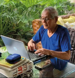 Kenzo Yamamoto, autor dominico-japonés, escribiendo en su computadora rodeado de vegetación